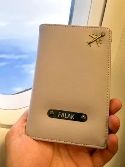 Travel in style with a personalized passport holder. This one is shown with a name and an airplane charm, making it the perfect accessory for your next trip.