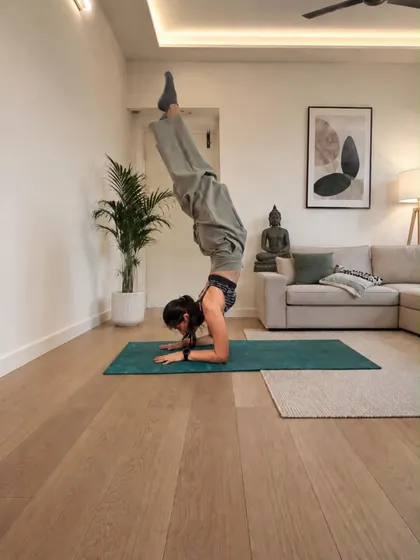 Forearm stand in a calm living room, legs folded overhead, shared on International Yoga Day 2026.