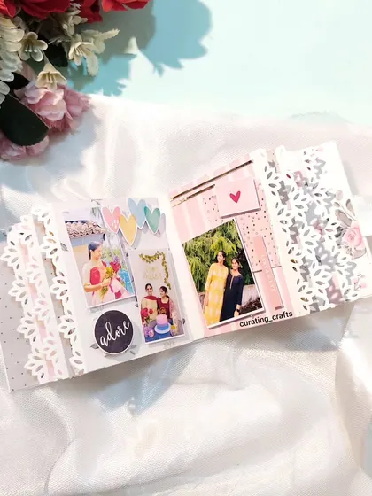 An inside page of the mini scrapbook, featuring delicate lace-edge pages and photo spots.