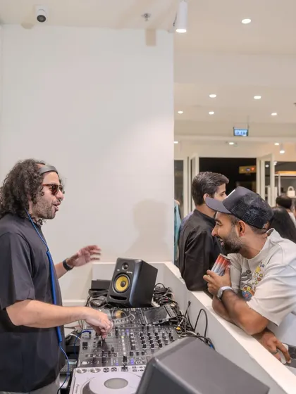 Chatting with a guest while DJing the Amiri store launch in Delhi. I create a welcoming and cool atmosphere, interacting with guests while providing a seamless music experience.