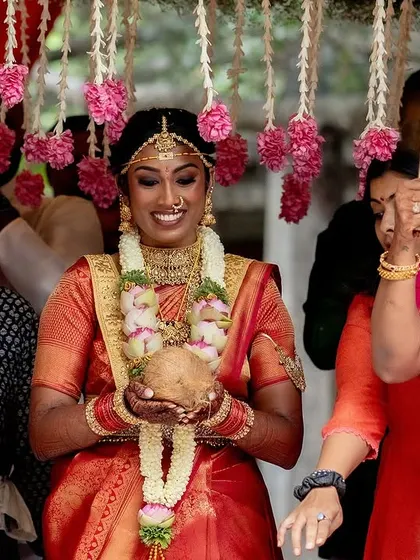 The bride's radiant smile as she makes her entrance, holding a sacred coconut, ready to begin her wedding ceremony.