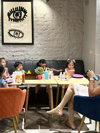 A group of children and a parent enjoying snacks and drinks at a table in our café. It's a great spot to refuel after a fun play session.