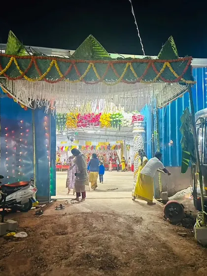 A traditional chapra entrance for a temple event. The arch is made from palm leaves and decorated with marigold garlands and mango leaves.