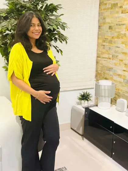 Adding a pop of color with a bright cardigan is an easy way to elevate a simple all-black base outfit. This layering technique is perfect for adapting to temperature changes and adding personality to your maternity style.