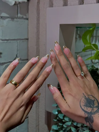 A classy twist on the classic French manicure. We used a beautiful gold chrome to create a luxurious and modern tipped look.