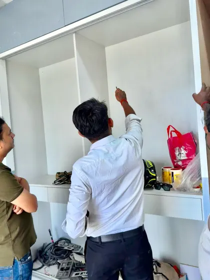 On-site, marking the precise points for fittings inside a custom wardrobe unit during its construction.
