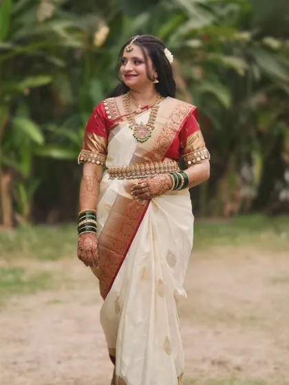 A full-length shot of the bride in her beautiful white and red South Indian saree, perfect for a temple wedding.