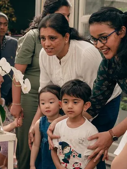 Teachers point out different flowers to the children, helping them learn the names and colors of various plants.
