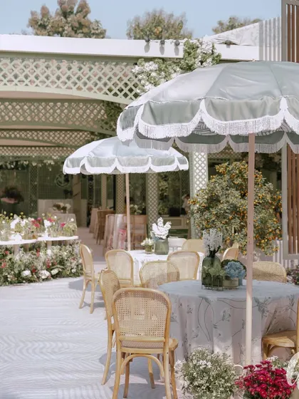 The outdoor seating area for the spring luncheon, complete with elegant fringed umbrellas. This setup shows how we design functional and beautiful spaces for guests to enjoy the outdoors in comfort.
