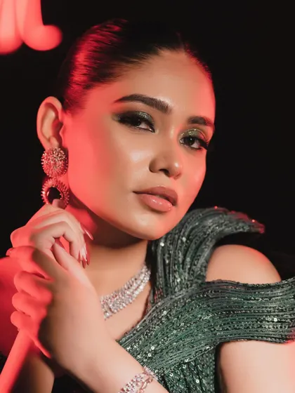 The red lighting adds a dramatic flair, but the makeup still shines through. The skin looks flawless and the eyes are mesmerizing.