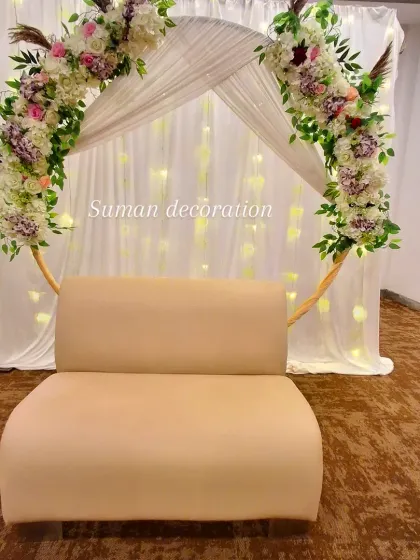 Another angle of the floral arch with the fairy light backdrop, showing the setup in a party hall.