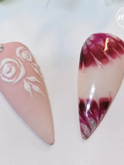 Two beautiful designs side-by-side. On the left, a matte pink nail with embossed white roses, and on the right, a glossy nail with a deep red feathered marble effect.