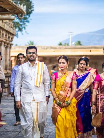 A shot of the wedding procession at a temple, with traditional musicians leading the way.