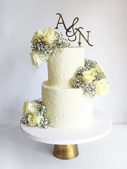 Happy people make my grid happy! This signature white cake was for a lovely couple's anniversary celebration. The two tiers are decorated with fresh white roses and baby's breath.