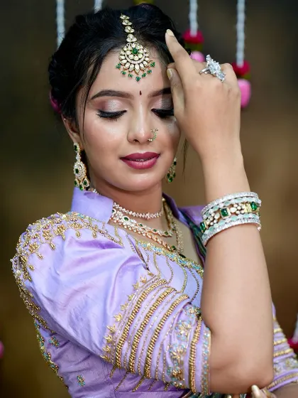 A serene pose highlighting the maang tikka and the soft, glowing makeup that complements the jewellery.
