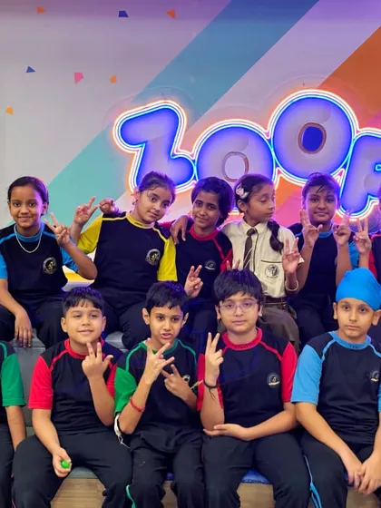 A group of students from Kanha Makhan Millennium School pose by the Zooper logo, full of energy.