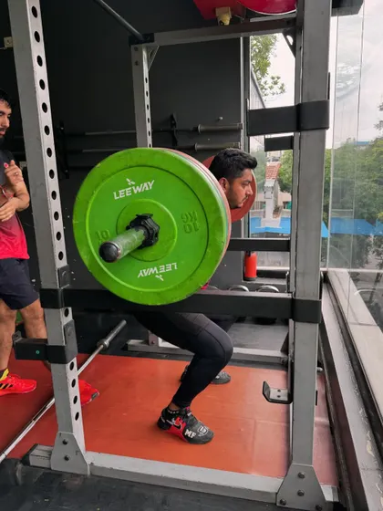 A client performs a heavy squat in the power rack. This is where strength is built, one rep at a time.