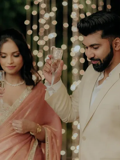 The couple raises a toast with champagne, celebrating their engagement with friends and family.