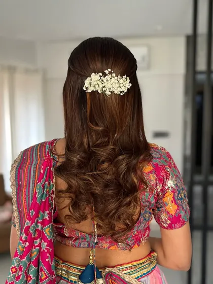 A perfect blend of elegance and charm for an engagement day. This half-up, half-down hairstyle with soft curls is decorated with a delicate baby's breath accessory.