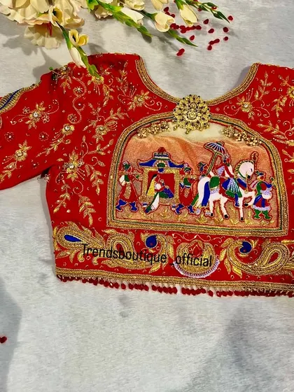 A full view of the red Dolly Palaki bridal blouse. The design includes the groom's procession with musicians and peacocks on the sleeves, creating a complete wedding story.