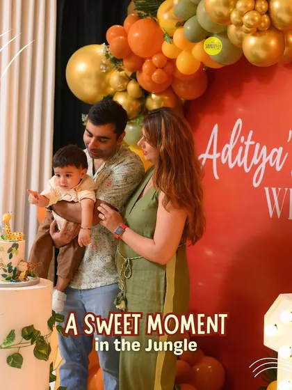 A sweet moment in the jungle. The family gathers for the cake cutting in front of the vibrant, jungle-themed backdrop I designed for Aditya's first birthday.