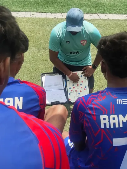 Coach giving tactical instructions during a water break in a C Division match.