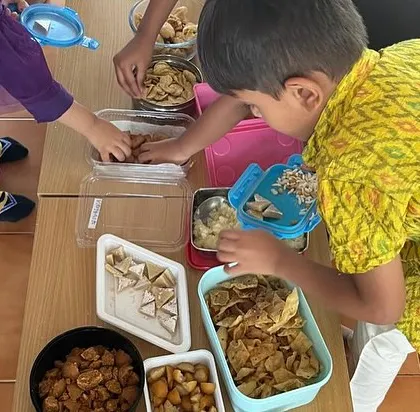 Community snack time is an important practical life activity. Children serve themselves and share food, learning grace, courtesy, and independence.