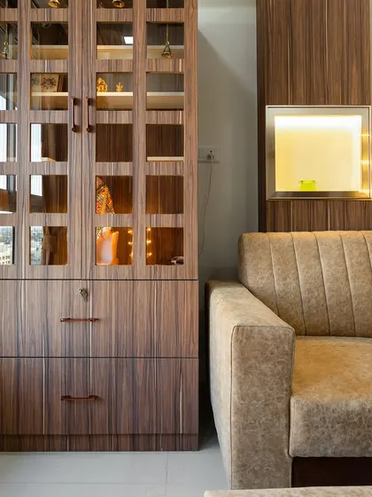 A close-up of a custom-built unit that combines a crockery cabinet with a display niche, all in a rich, dark wood finish.