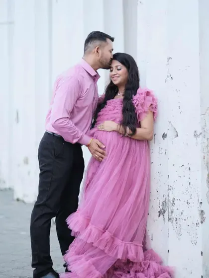 A tender moment between parents-to-be. This soft pink ruffled maternity gown is perfect for capturing the sweet anticipation of your little one's arrival.