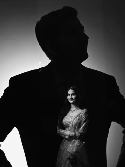 A creative double exposure portrait where the bride is beautifully contained within the silhouette of her groom, symbolizing their union.