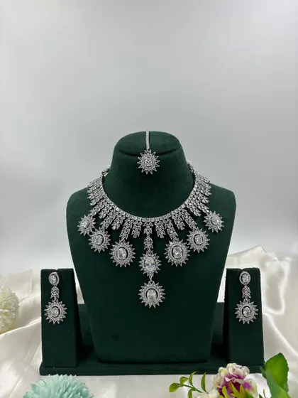 Showcasing the modern side of our collection, this silver-plated American Diamond set features a unique sunburst design. It's available in multiple stone colors including white, black, and mint green, perfect for cocktail parties and contemporary tastes.