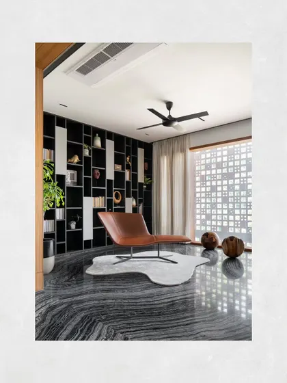 The library in Kamala Residence, where the dramatic black marble floor reflects the light from the window, creating a dynamic and inspiring atmosphere for reading.