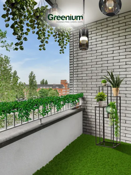 The "after" shot of a balcony transformation. The combination of artificial grass, a stylish plant stand, and hanging greenery against the white brick wall creates a fresh and inviting atmosphere.
