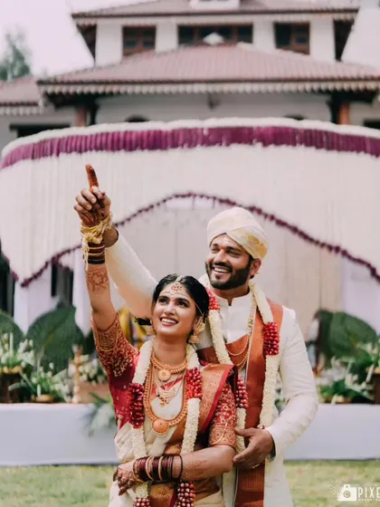 A moment of shared joy and excitement during the wedding ceremony, with the beautiful floral decor in the background.