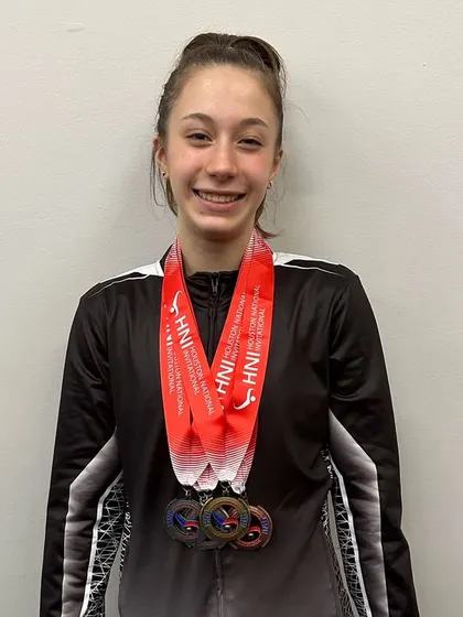 A happy gymnast from our Optional Team showing off her medals from the HNI meet.