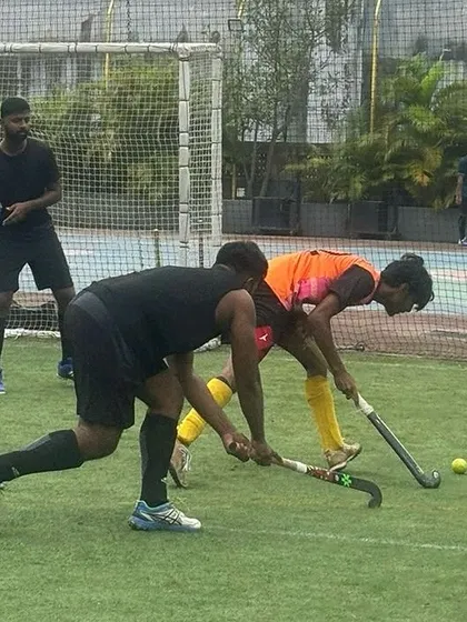 A defender challenges an attacker for the ball near the goal. These game-like scenarios are essential for honing both offensive and defensive skills.