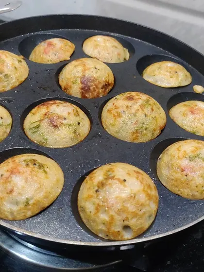 A pan full of appe, showing the satisfying process of making these delicious South Indian dumplings.