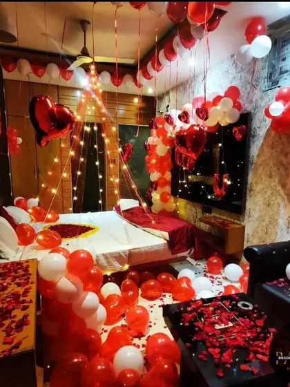 An immersive Valentine's Day room decoration where the entire space is filled with red and white balloons and rose petals.