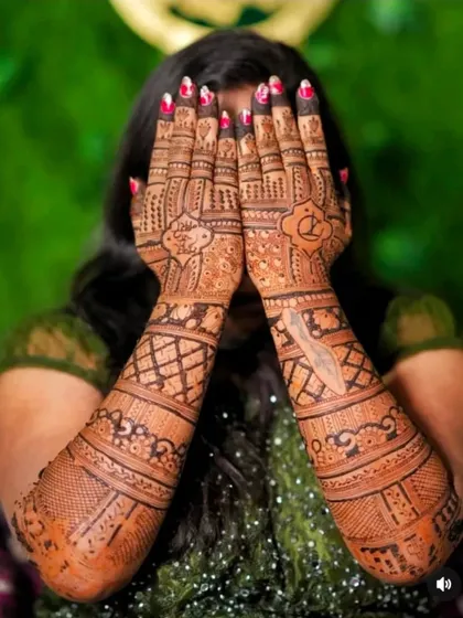A classic "peek-a-boo" pose that beautifully showcases the intricate mehndi design on the back of the hands.
