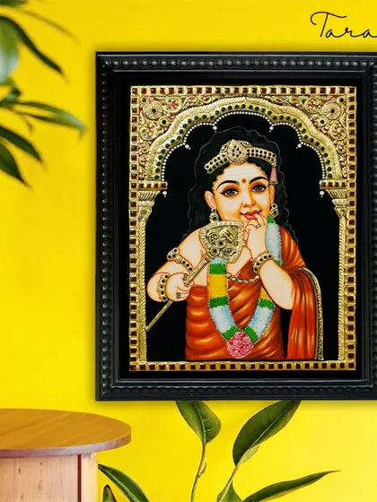A charming Tanjore painting of a young Lord Murugan. This artwork captures the innocent yet divine nature of the child deity, adorned with traditional jewelry and holding his divine spear (vel).