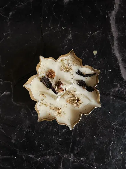 A top-down shot of my copper urli floral candle, decorated with natural botanicals.
