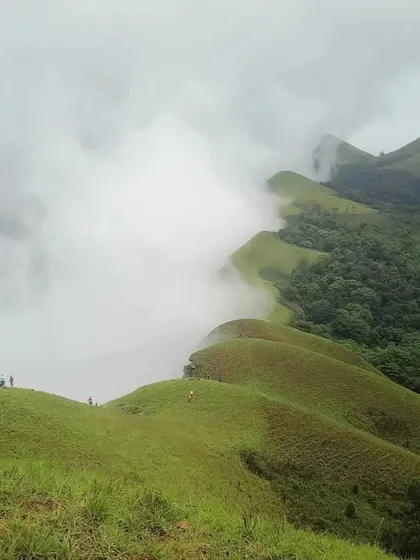 A breathtaking view of the Netravati peak range, with its distinctive spine-like ridges disappearing into the clouds.