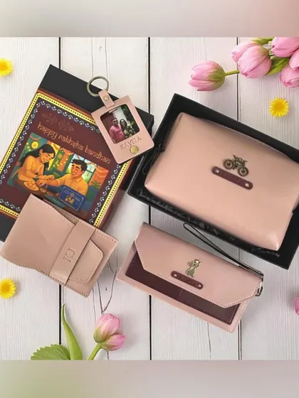 This Rakshabandhan hamper for a sister features a beautiful set of personalized vegan leather accessories in shades of pink. It includes a clutch, wallet, and a photo keychain, all with custom charms.