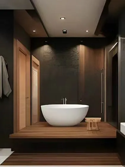 A modern bathroom with a dark, moody aesthetic. The design features a freestanding tub on a raised wooden platform, creating a focal point and a spa-like experience.