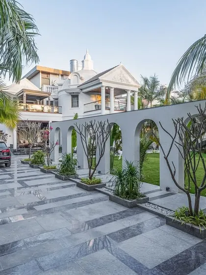The arched wall at the Tropical Manor serves to subtly define spaces without creating hard barriers. During the day, the structure frames unique views of the landscape, while the carefully chosen flooring patterns complement the rhythm of the arches.