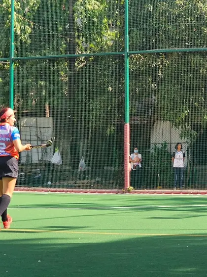 A player looks on from a distance, assessing the play during the semi-final match. Strategic thinking and field awareness are skills we emphasize in our training.