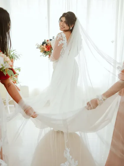 A lovely moment as the bridesmaids help with the bride's veil.