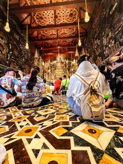 A quiet moment inside one of Bangkok's ornate temples. We always take time to appreciate the local culture and history.