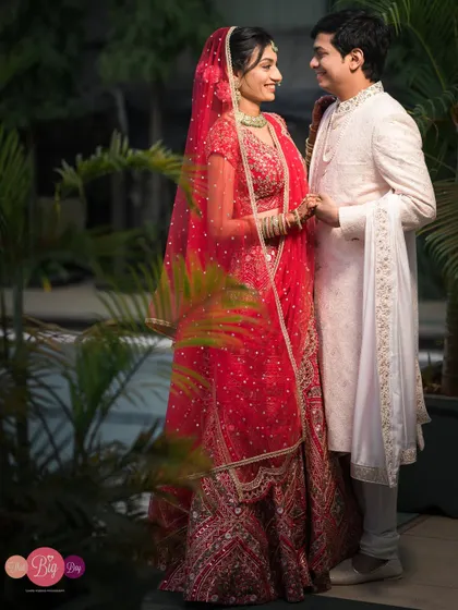 A classic wedding portrait of Arpita and Mahesh, the bride's red lehenga a beautiful contrast against the groom's white sherwani.