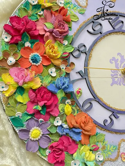 A detailed view of the vibrant flowers at the base of the lavender clock, showing a rainbow of colors from orange and yellow to blue and purple.